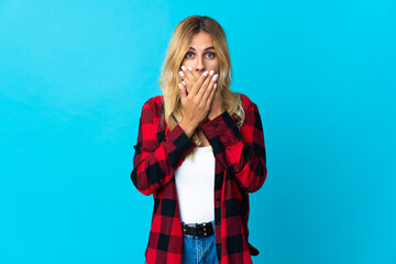 Young blonde Uruguayan woman over isolated background covering mouth with hands