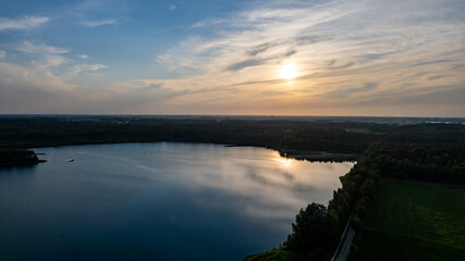 Aerial view shot by a drone of a beautiful dramatic and colorful sunset at coast of the lake. Nature landscape. Nature in Europe. reflection, blue sky and yellow sunlight. landscape during sunrise or