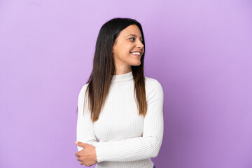 Obraz premium Young caucasian woman isolated on purple background looking to the side and smiling