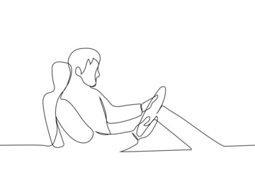 man sitting in a chair and holding a steering wheel - one line drawing vector. driving learning concept, driving simulator test, driving game