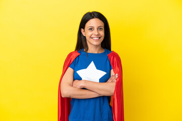 Woman isolated on yellow background in superhero costume with arms crossed