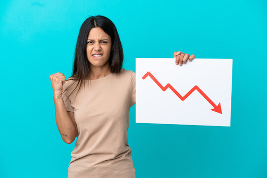 Young woman over isolated background holding a sign with a decreasing statistics arrow symbol and angry