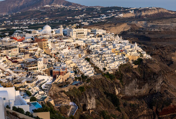 Fototapeta premium The whitewashed town of Fira in warm rays of sunset on Santorini island, Cyclades, Greece