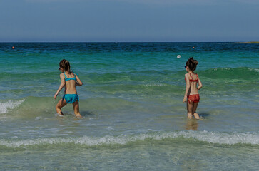 Bambine di sette anni che giocano in acqua al mare.