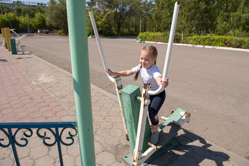 City sports ground, the girl is engaged in simulators.