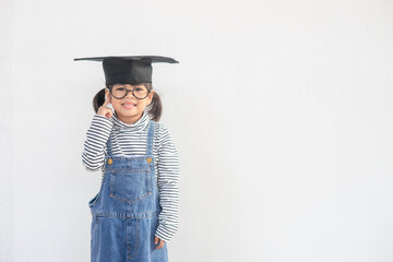 Happy Asian school kid graduate thinking with graduation cap