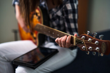 Fototapeta premium Teenage girl is playing guitar at home.