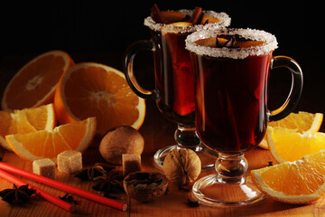 Two cups with ready mulled wine with anise, cinnamon and nuts around