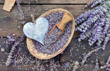 decorative metal heart in a little basket full of  of lavender on wooden table