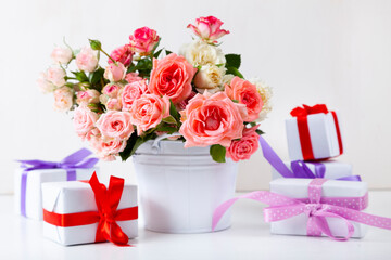 Bouquet of pink roses and boxes with gifts