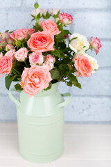 Bouquet of pink roses on a light wooden background.