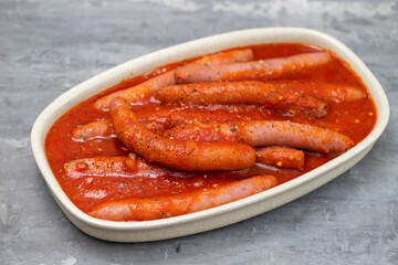 fresh sausages with tomato sauce on the dish