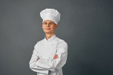 chef Professional with serious expression holds hands in front of him dark background