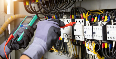 Electrician engineer tests electrical installations and wires on relay protection system....