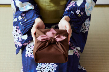 贈り物を差し出す和服姿の女性の手元