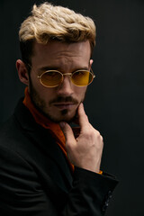 Obraz premium Gentleman in suit holds his hand near the face hairstyle model 