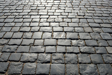 An old cobblestone road. European old paving made of stones.