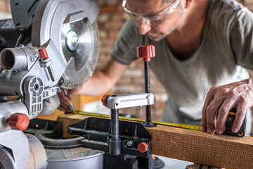 Professional carpenter working with a miter saw.