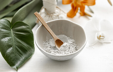 Spa composition with powder face mask and flowers.