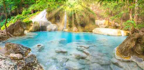 Panorama of emerald blue lake with rock cascades of stream waterfall in tropical jungle forest....
