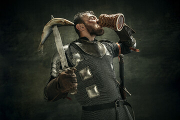 Portrait of one brutal bearded man, medeival warrior or knight over dark background.