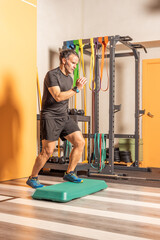 Fototapeta premium Man doing step up jumps in health club
