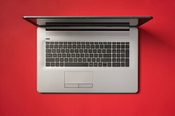 Fototapeta na wymiar Top view photo of open grey laptop on isolated vivid red background