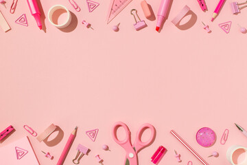 Top view photo of school accessories pink stationery on isolated pastel pink background with empty space in the middle