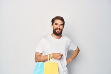 Cheerful man in white t-shirt with packs of shopping emotions lifestyle