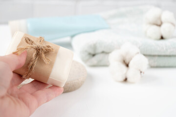 Woman's hand puts new bar of soap on tray in the bathroom.
