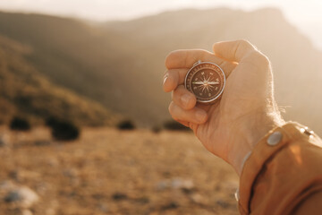 Point of View. Compass in a man's hand against the background of a mountain landscape.