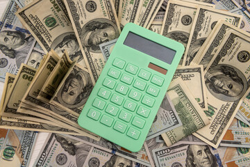 Calculator and 100 dollar bills