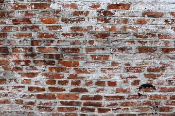 Old brick wall with cracks of rural building