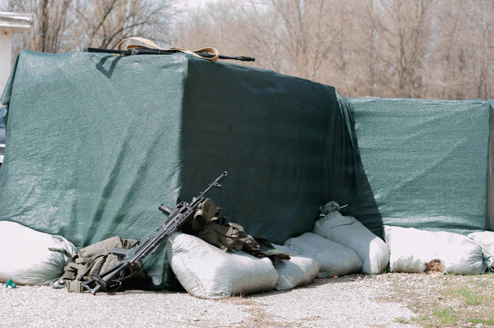 Weapons and equipment for playing airsoft lying on the ground and defensive structures