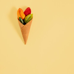 Jalapeno and habanero hot chili peppers in ice cream cone. Minimal flat lay composition on yellow background with copy space