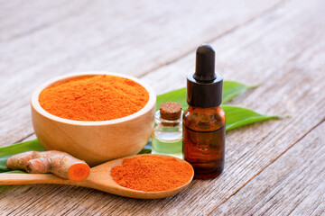 turmeric essential oil isolated on wood table