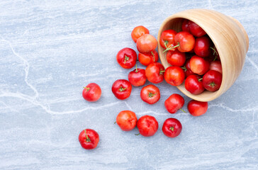 Acerola cherry fruits (Malpighia Glabra) in wooden bowl isolated 