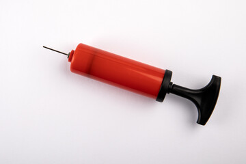 Red pump to inflate the ball on a white background