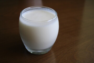 Glass of kefir drink on wooden table