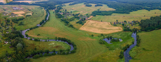 Aerial landscape of winding river in green field, top view of beautiful nature background from drone, seasonal summer landscape with copy space.