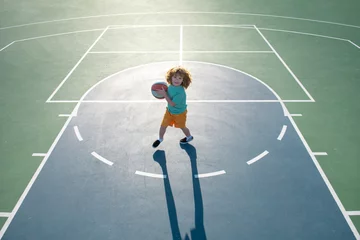 Foto op Plexiglas Child boy preparing for basketball shooting, outdoor on playground. © Volodymyr