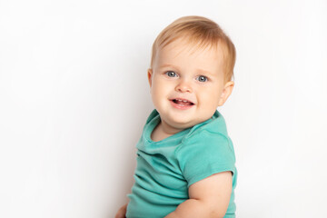 Naklejka premium Infant child baby boy in green t-shirt laughs happy looking at the camera isolated on a white background. Childcare and upbringing concept.