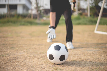 Fototapeta premium Sports and recreation concept a male goalkeeper standing in front of the goal throwing a ball as distributing in to a player after protecting the goal
