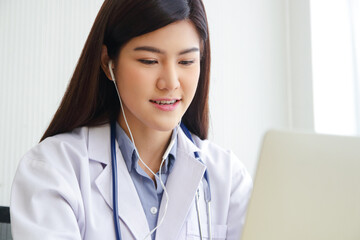 Asian female doctor online video call Check the symptoms with the patient via the Internet. on a laptop computer. The concept is connected to communication through online technology.