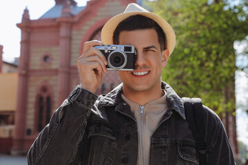 Fototapeta premium Tourist taking picture on beautiful city street