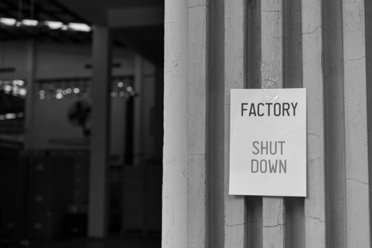 Factory Shut Down sign in front of the factory warehouse. Business shutdown because of economic recession and Coronavirus Covid-19.