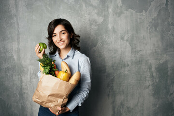 woman with a package of groceries supermarket diet food dark background