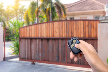 hand using remote controlled to open sliding door.