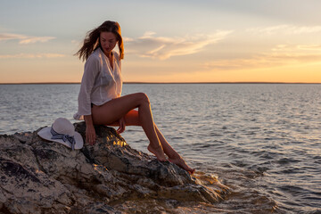 Fototapeta na wymiar Beautiful woman enjoying sunset on the beach.