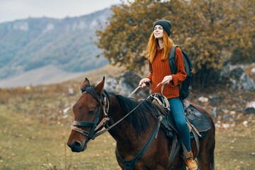 woman hiker rides a horse on nature in the mountains